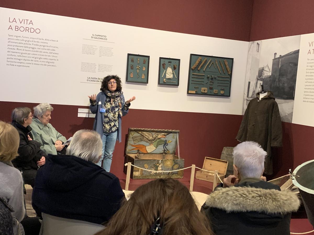 educatore in mostra che parla ad un pubblico di persone